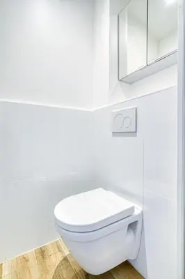 a white bathroom with a toilet and a mirror at Le Marignan in Cannes