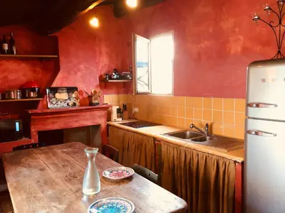 a kitchen with a wooden table and a sink at Appart Suquet Avec Terasse Vue Mer in Cannes