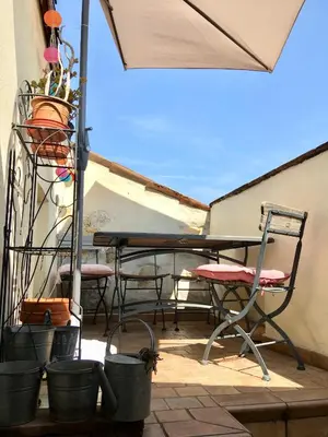 a patio with a table and chairs and an umbrella at Appart Suquet Avec Terasse Vue Mer in Cannes