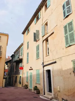 an old building with green shutters on a street at Appart Suquet Avec Terasse Vue Mer in Cannes