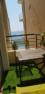 a wooden bench on a balcony with a view of the ocean at 45 Clemenceau by Welcome to Cannes in Cannes