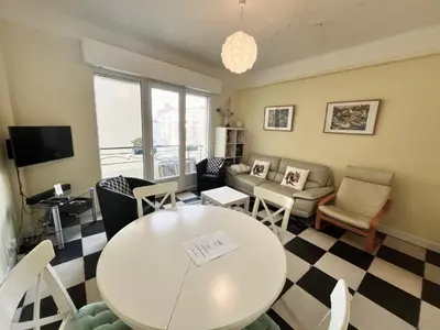 a living room with a table and chairs at 45 Clemenceau by Welcome to Cannes in Cannes