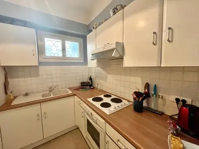 a kitchen with white cabinets and a stove top oven at 45 Clemenceau by Welcome to Cannes in Cannes