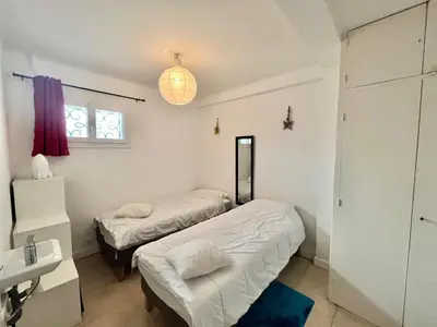 a bedroom with two beds and a sink and a mirror at 45 Clemenceau by Welcome to Cannes in Cannes