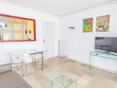 a living room with a table and a tv at Lovely One bedroom Martinez Cannes in Cannes
