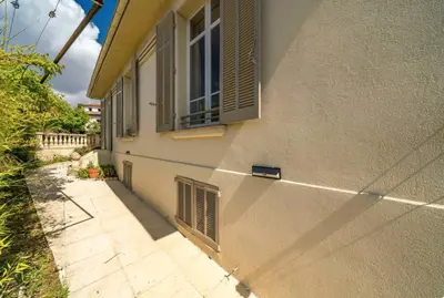 a building with an open window and a sidewalk at les néfliers in Cannes
