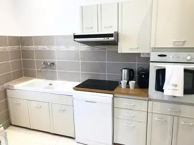 a kitchen with white cabinets and a sink at les néfliers in Cannes