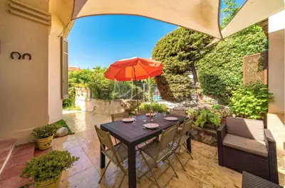 a table with an umbrella on a patio at les néfliers in Cannes