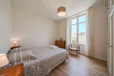 a bedroom with a bed and a large window at les néfliers in Cannes