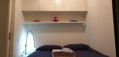 a small bedroom with a bed and a shelf at Parc Impérial in Cannes