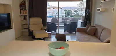 a living room with a table with a bowl of fruit on it at Parc Impérial in Cannes