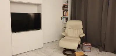 a living room with a chair and a flat screen tv at Parc Impérial in Cannes