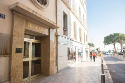 a building on a street with people walking in front of it at ACCI Cannes Croisette in Cannes