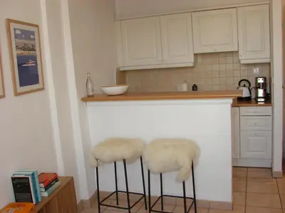 a kitchen with two bar stools with faux fur covers at ACCI Cannes Croisette in Cannes