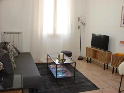 a living room with a couch and a tv at ACCI Cannes Croisette in Cannes