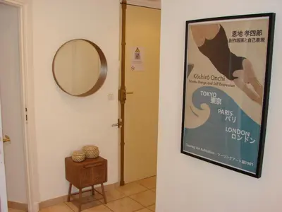 a hallway with a poster on the wall and a mirror at ACCI Cannes Croisette in Cannes