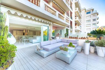 a patio with a white couch and some plants at Appartement l'Age d'Or in Cannes