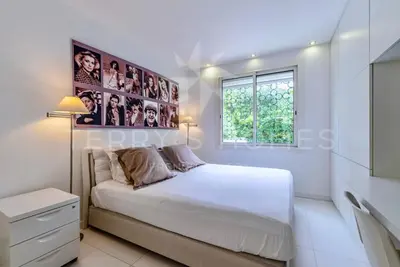 a bedroom with a large white bed and a window at Appartement l'Age d'Or in Cannes