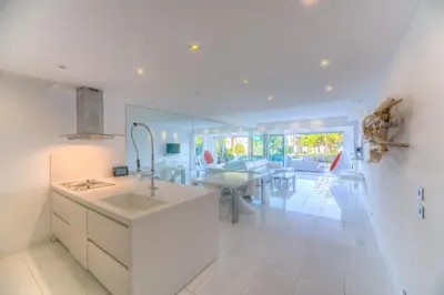 a white kitchen with a sink and a table at Appartement l'Age d'Or in Cannes