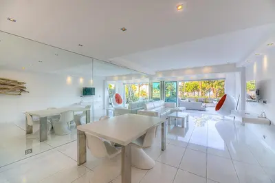 a living room with tables and chairs and a couch at Appartement l'Age d'Or in Cannes
