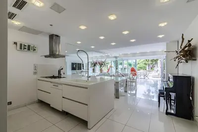 a white kitchen with a sink and a table at Appartement l'Age d'Or in Cannes