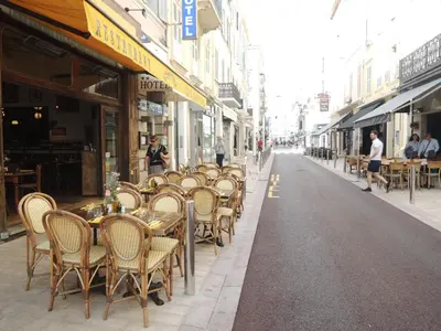 a row of tables and chairs on a city street at Fabulous Central 1BR - Prime Location - Walk to Croisette & Palais - By Totolulu Cannes Blue Corner in Cannes