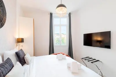 a bedroom with a white bed and a window at Fabulous Central 1BR - Prime Location - Walk to Croisette & Palais - By Totolulu Cannes Blue Corner in Cannes
