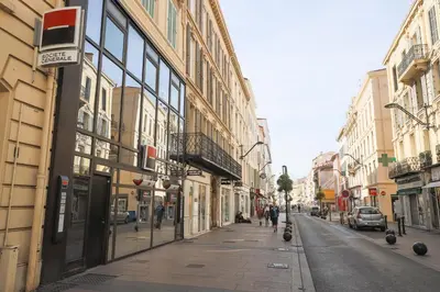 an empty city street with people walking down the street at ACCI Cannes Riviera in Cannes