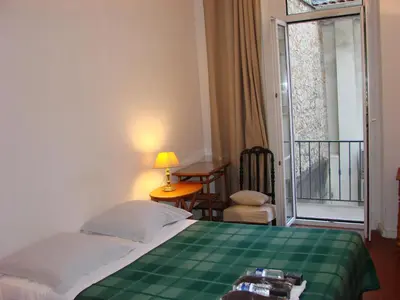 a bedroom with a green bed with a table and a window at ACCI Cannes Riviera in Cannes