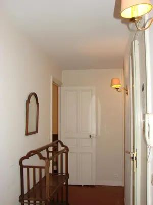 a room with a door and a chair and a mirror at ACCI Cannes Riviera in Cannes