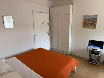 a bedroom with a bed with an orange blanket at ACCI Cannes Riviera in Cannes
