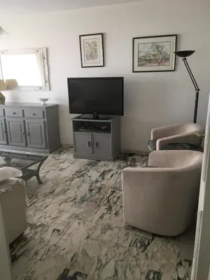 a living room with a flat screen tv and chairs at Lou Suquetan in Cannes
