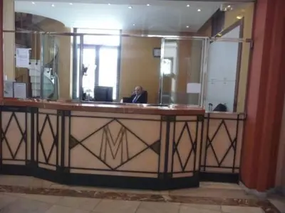 a man sitting at a desk in front of a mirror at Studio Cannes Croisette in Cannes