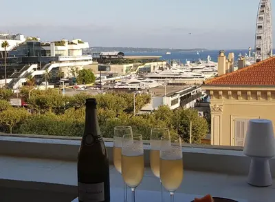 a bottle of wine and wine glasses on a ledge at La Goelette - Palais des Festivals in Cannes