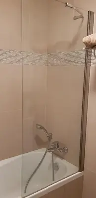 a shower with a glass door next to a bath tub at La Goelette - Palais des Festivals in Cannes