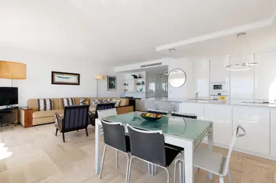 a kitchen and living room with a table and chairs at Mer du Sud 4 YourHostHelper in Cannes