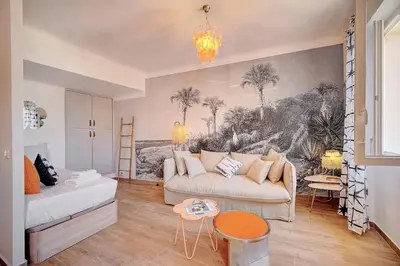 a living room with a couch and a painting on the wall at IMMOGROOM - Sea view apartment - 3 min from beach - AC in Cannes