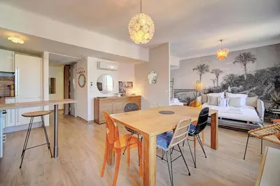 a kitchen and living room with a table and chairs at IMMOGROOM - Sea view apartment - 3 min from beach - AC in Cannes