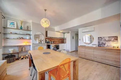 a kitchen with a wooden table and a dining room at IMMOGROOM - Sea view apartment - 3 min from beach - AC in Cannes
