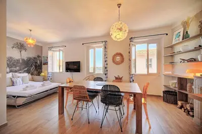 a dining room and living room with a table and chairs at IMMOGROOM - Sea view apartment - 3 min from beach - AC in Cannes