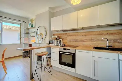 a kitchen with white cabinets and a counter with a sink at IMMOGROOM - Sea view apartment - 3 min from beach - AC in Cannes