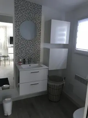 a white bathroom with a sink and a mirror at Les fleurs in Cannes