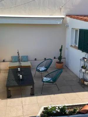 a patio with two chairs and a wooden table and chairs at Les fleurs in Cannes