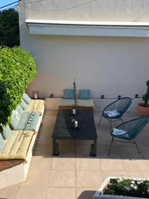 a patio with two benches and a table and chairs at Les fleurs in Cannes