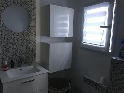 a bathroom with a sink and a mirror and a window at Les fleurs in Cannes