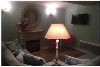 a living room with a couch and a lamp and a mirror at Winter Palace Cannes in Cannes