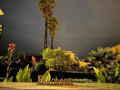 a stormy sky with palm trees and a sign at Winter Palace Cannes in Cannes
