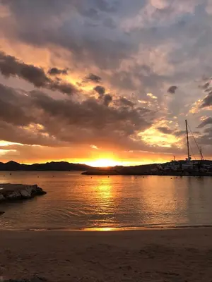 a sunset over a body of water with a beach at 2BDR Reine Astrid in Cannes