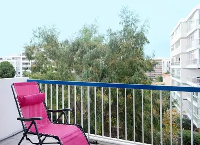 a pink chair sitting on the balcony of a apartment at 2BDR Reine Astrid in Cannes