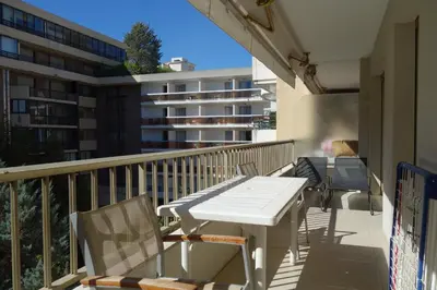a patio with a white table and chairs on a balcony at Branly by Welcome to Cannes in Cannes